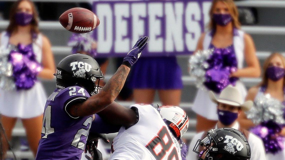 TCU safety Trevon Moehrig ends up intercepting a pass in the end zone against Oklahoma State and tight end Jelani Woods (89) during Saturday’s game in Fort Worth. The Horned Frogs won 29-22.
