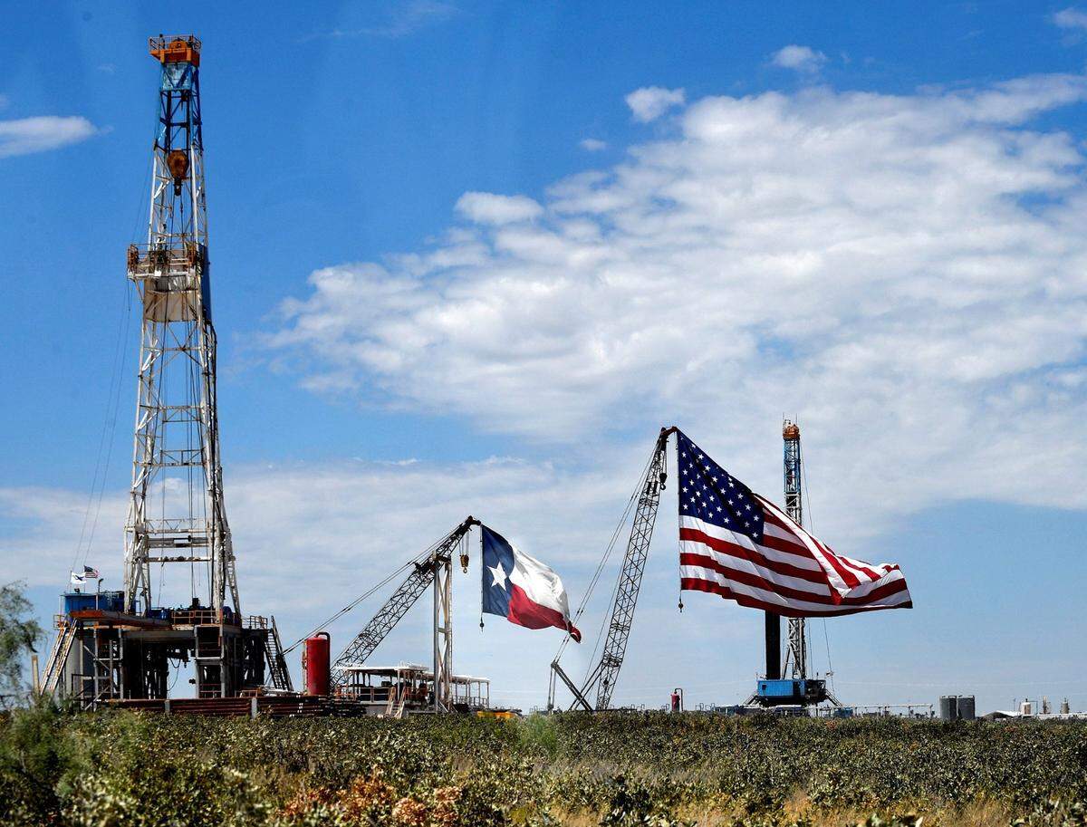 Oversized Texas and American flags fly from cranes at Double Eagle Energy outside of Midland in 2020.