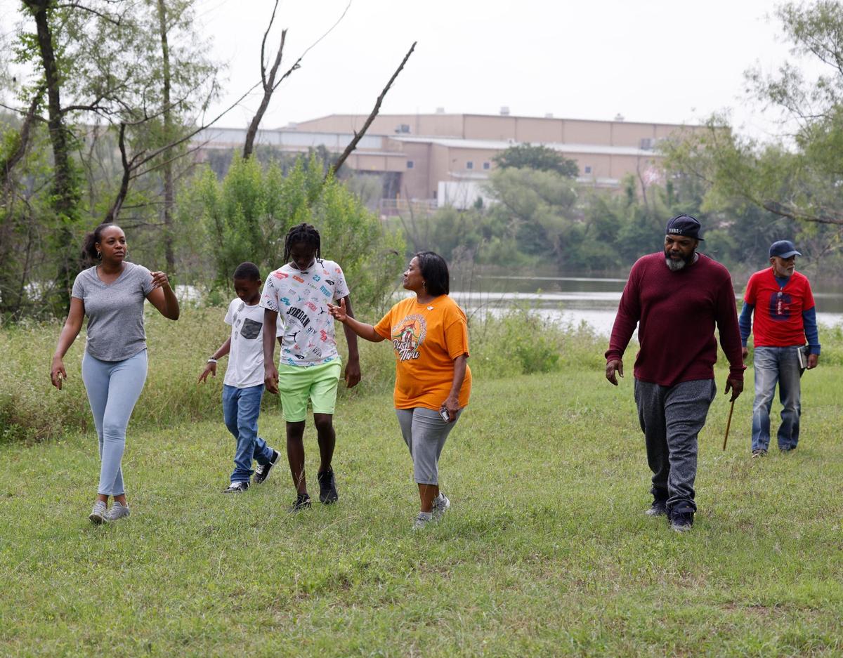 UTA professor Letora Anderson, her sons Daniel, 12, Kirby 14, Trina Sanders, Kareem Jefferson and Drew Sanders walk back from the lake in Fort Worth, Texas, Friday May 24, 2024. A recycling plant is on the other side of the lake. The Sanders have lived in The Garden of Eden, also known as a Freedman’s Community, almost since the neighborhoods beginnings.