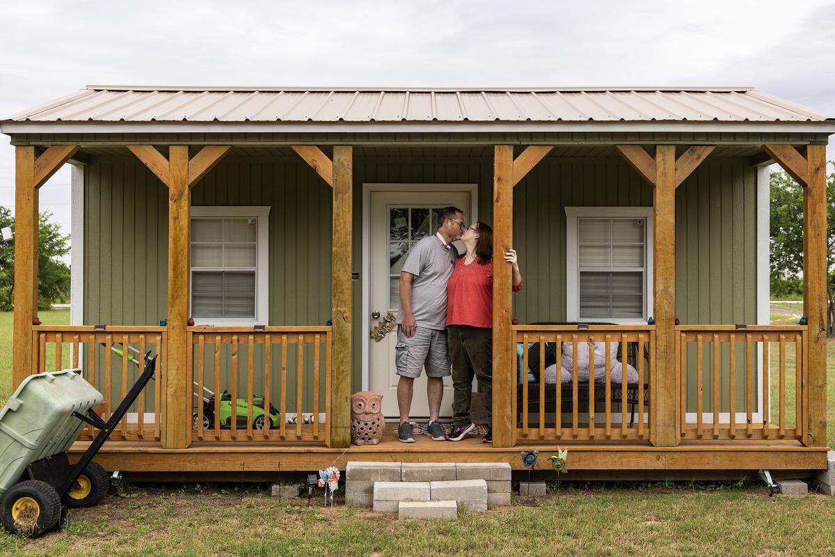 Kevin and Amy Kirkland kiss each other while on the porch of their backyard shed at their home in Haslet on Wednesday, May 28, 2025. The backyard shed contains items owned by their late daughter Katey and they remain reluctant to move her things out of the shed.
