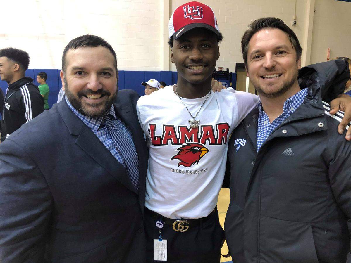 Nolan Catholic coaches David Beaudin and Jordan Hampton with cornerback Devin Thomas who signed with Lamar on Wednesday Feb. 5, 2020.