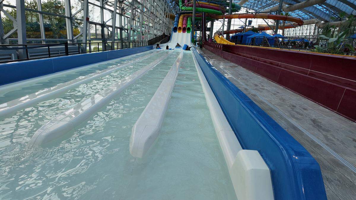 Four Epic Waters visitors dash down the E-Racer water slide on Wednesday, June 18, 2025 in Grand Prairie.