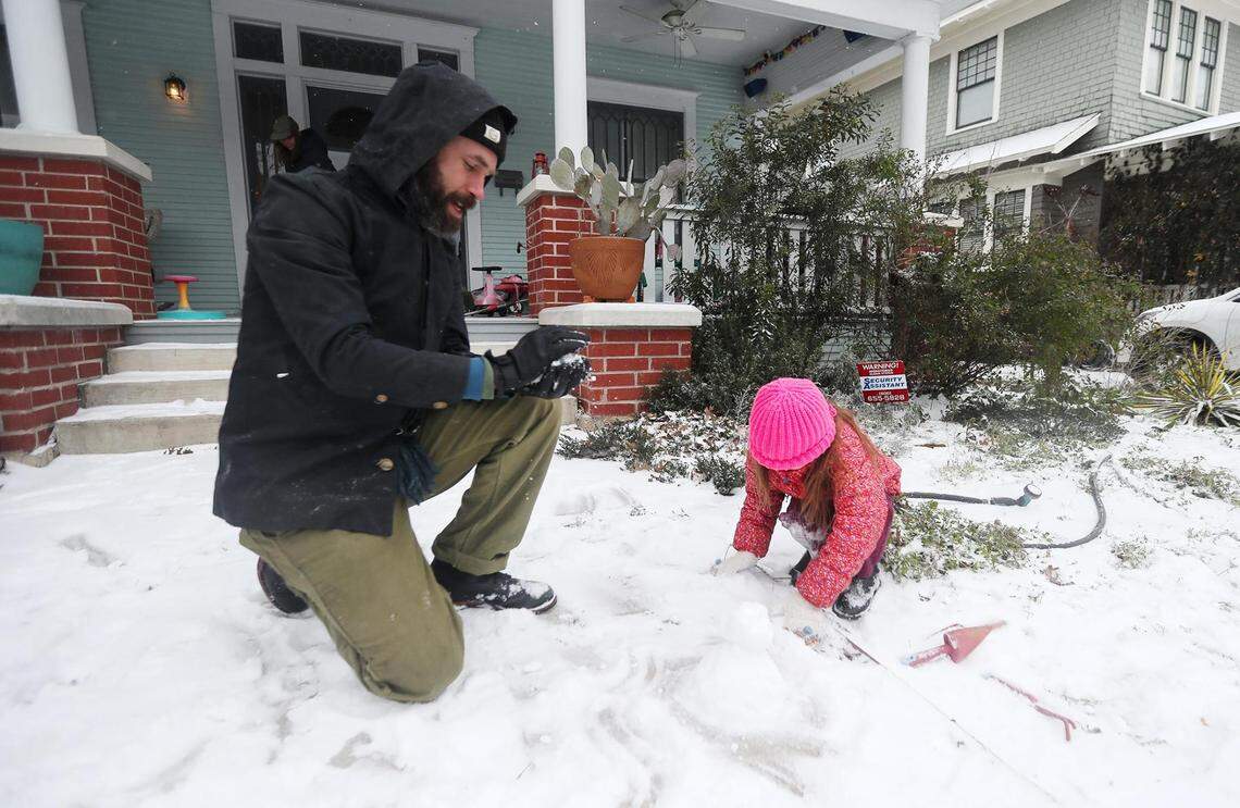 Josh Block, left, makes a tiny snowman with his daughter, Birdie, 5, on Feb. 14, 2021.