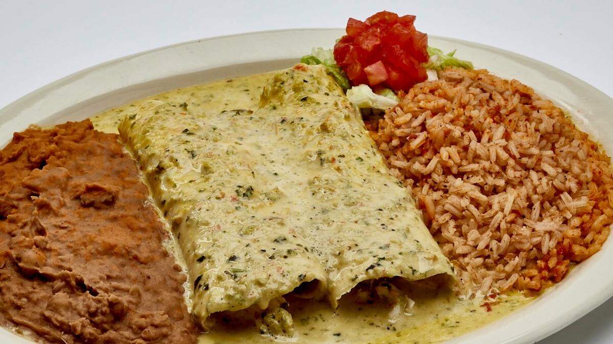 Chicken enchiladas with mild green chile queso “boom-boom” sauce at Chuy’s.