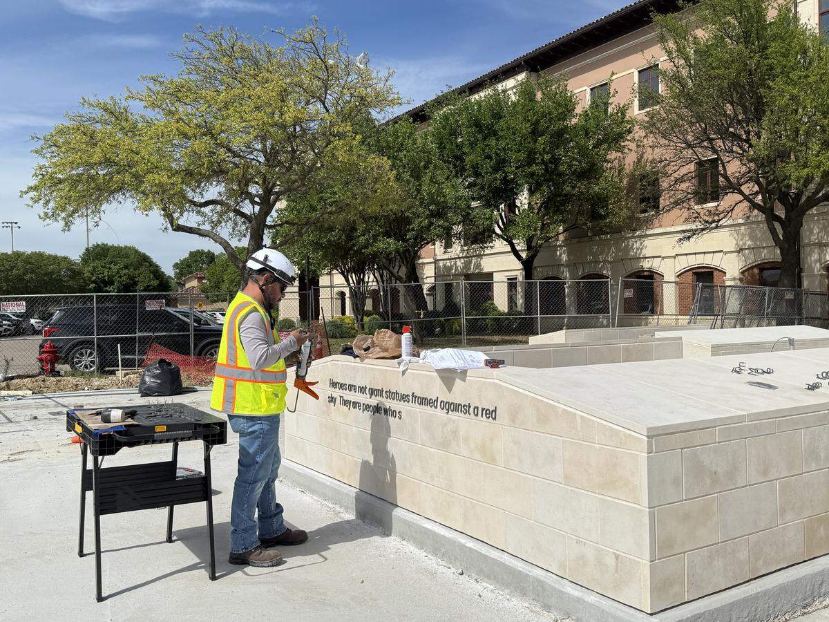 A construction worker adding a quote to an area of the Heroes Park.