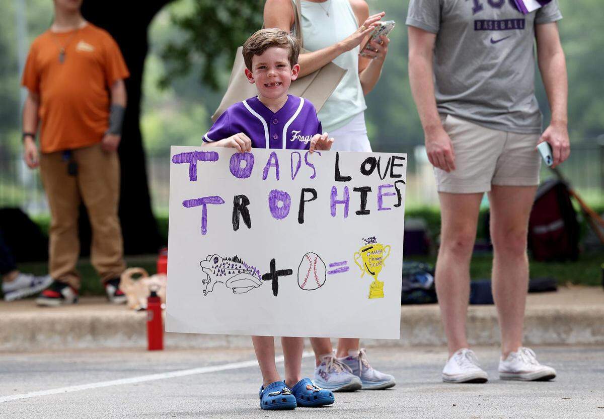 Henry Bredthauer holds up a handmade sign while waiting to send off the TCU baseball team on Wednesday, June 14, 2023, in Fort Worth.