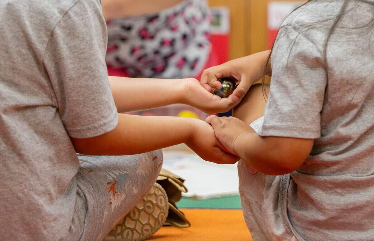 Allison Ramirez Gomez, left, passes a pair of objects to Alondra Villarreal during the pre-K prep program at Castleberry Elementary School in Fort Worth on June 29, 2026. The students passed around a heavy and light object to decide which would sink or float when dropped in water.