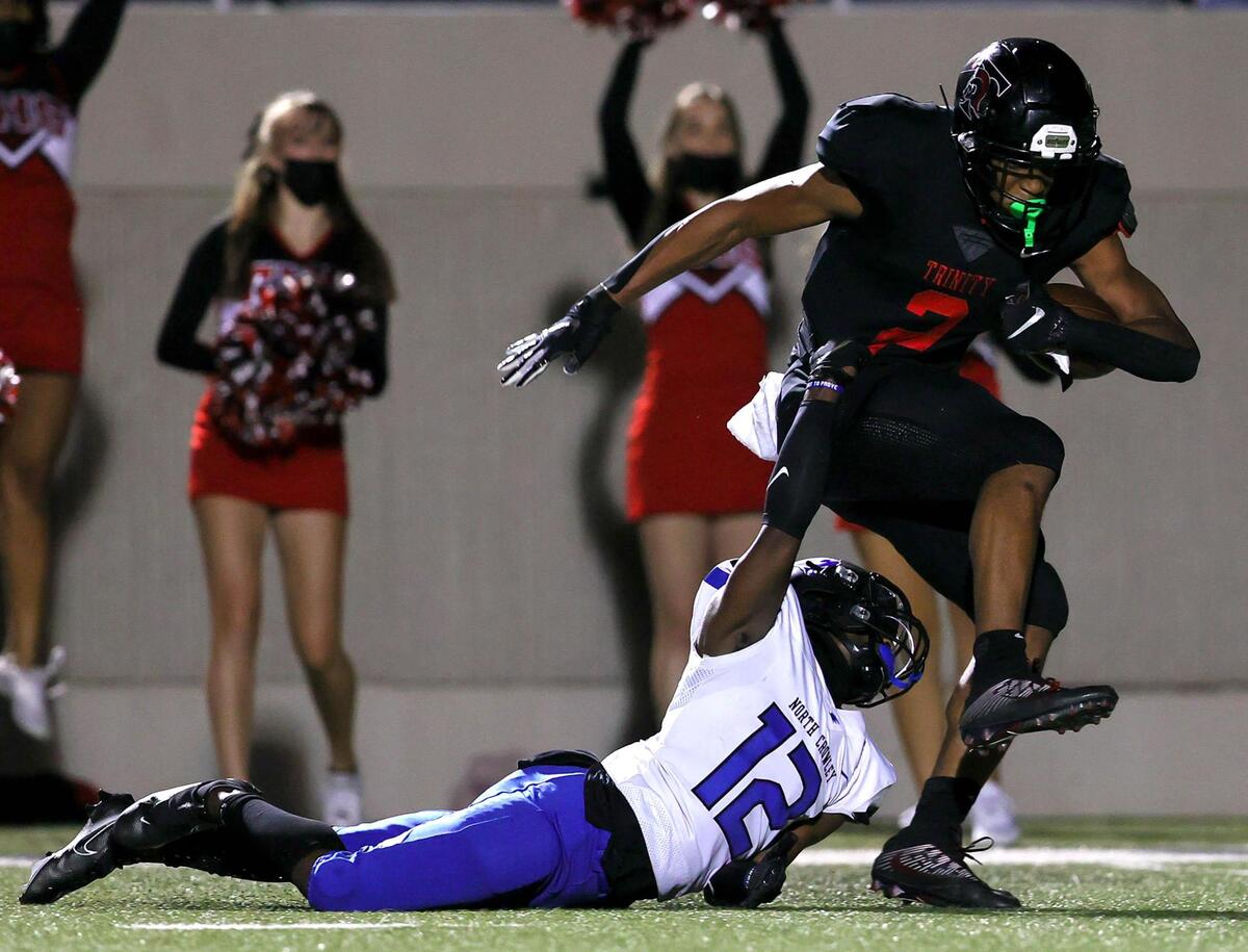 Trinity running back Ollie Gordon (2) goes 66 yards after being pulled down by North Crowley defensive back Joe Redick (12) during the first half of a high school football game, Thursday night, November 5, 2020 played at Pennington Field in Bedford, Tx. (Steve Nurenberg Special to the Star-Telegram)