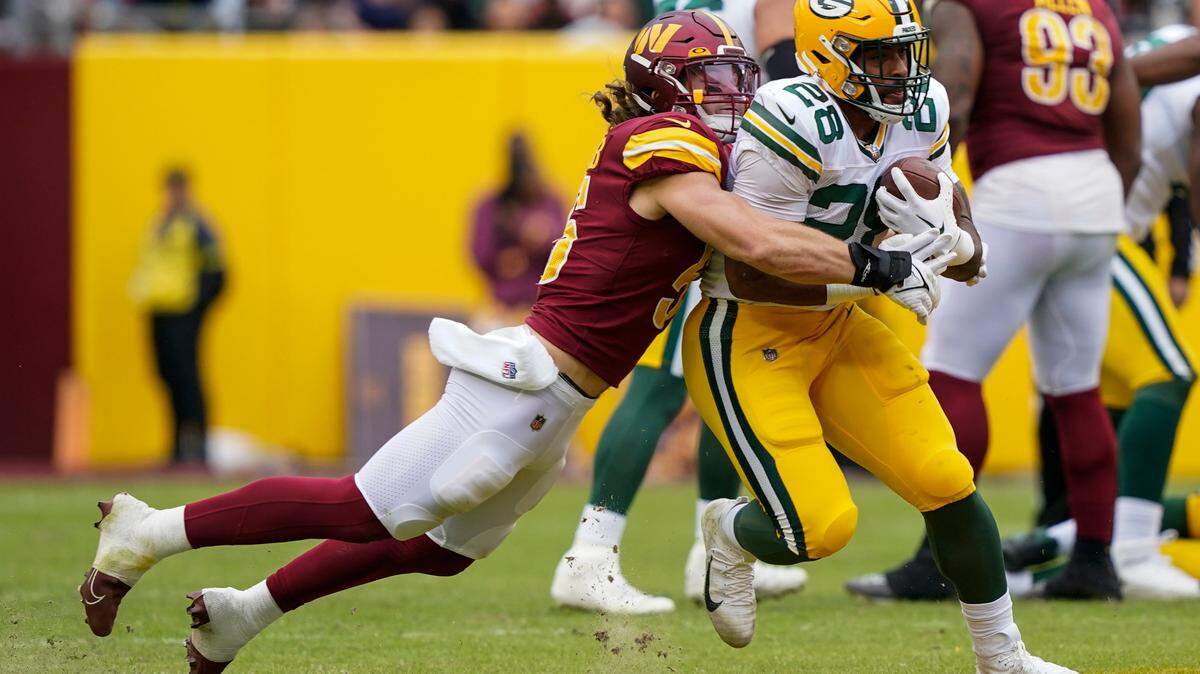 Washington Commanders linebacker Cole Holcomb (55) tackles Green Bay Packers running back AJ Dillon (28) during the second half Sunday in Landover, Md.
