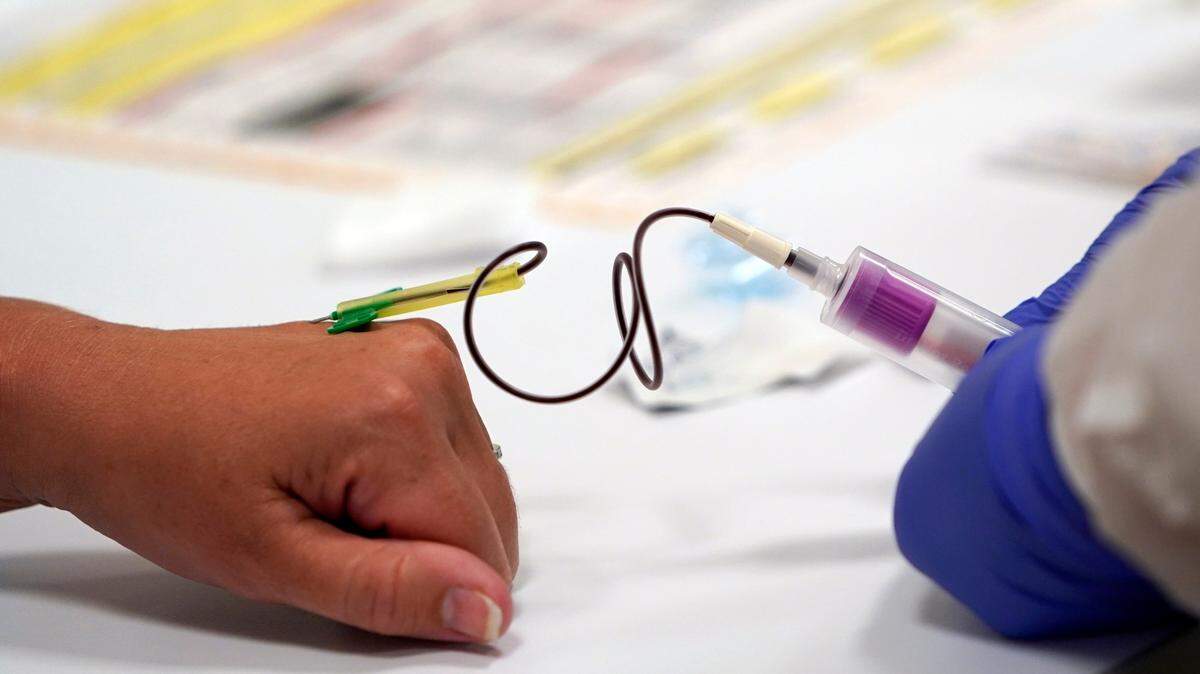 A phlebotomist draws blood from a patient for COVID-19 antibody testing at Principle Health Systems and SynerGene Laboratory in Houston in this file photo. The company offers a COVID-19 antibody test developed by Abbott Laboratories.