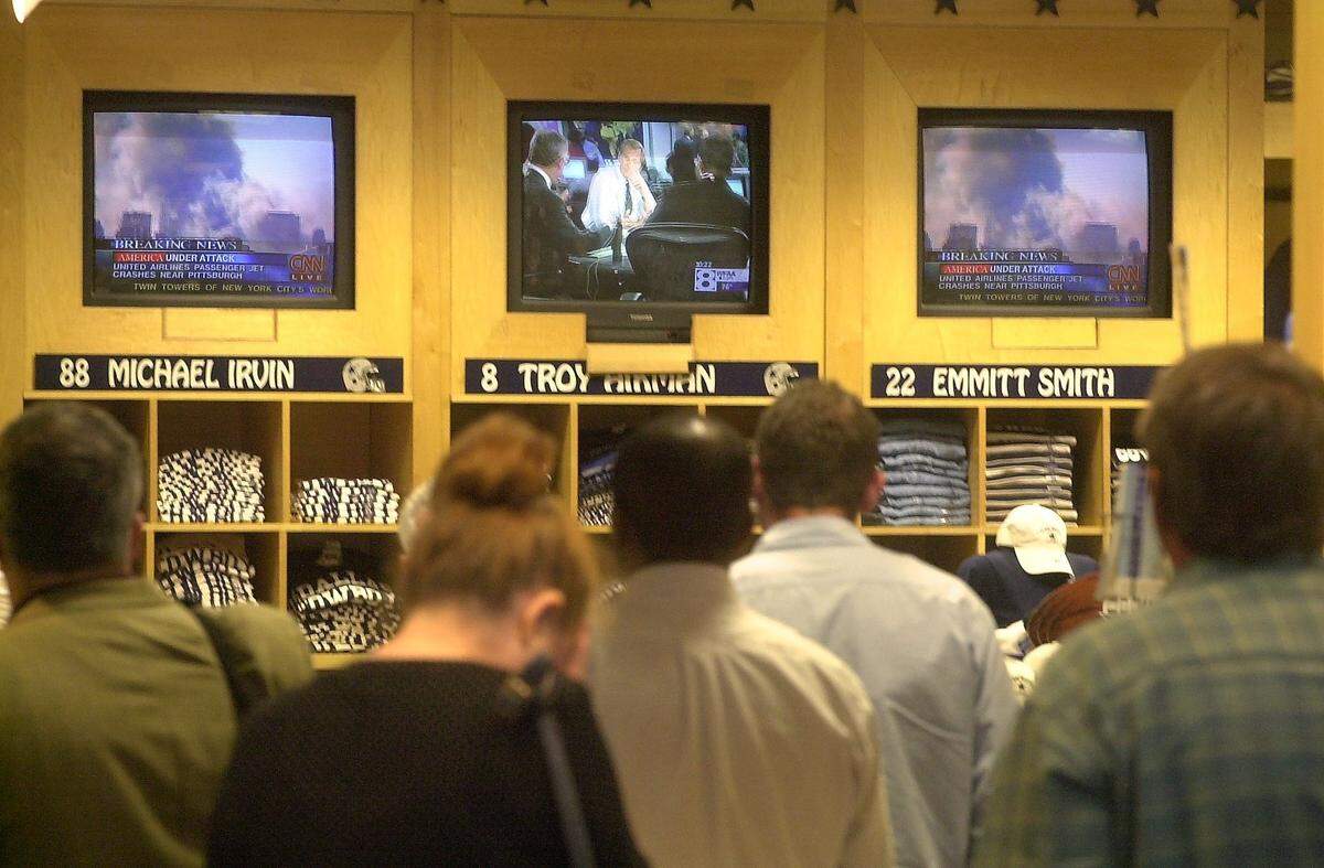 Stunned passengers at DFW International Airport’s Terminal A watch television at a store. Televisions in the terminal were turned off, and passengers were not told of the morning’s events while in flight. Passengers crowded the bars and stores with TV sets to learn more.