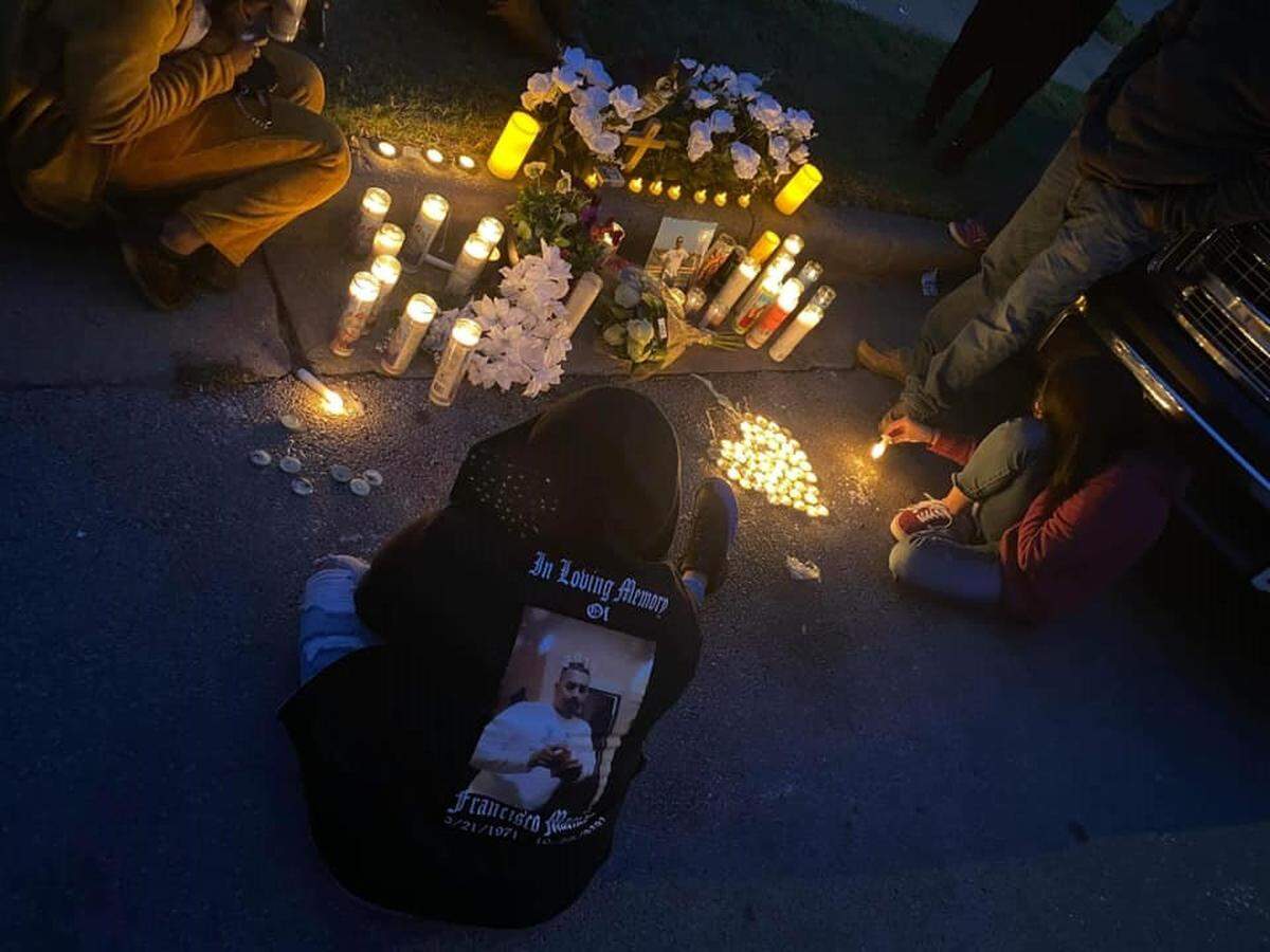 People gather around a candlelight vigil for Francisco “Panchito” Macias, a 49-year-old father and grandfather who was killed outside of his home in east Fort Worth in October 2020.