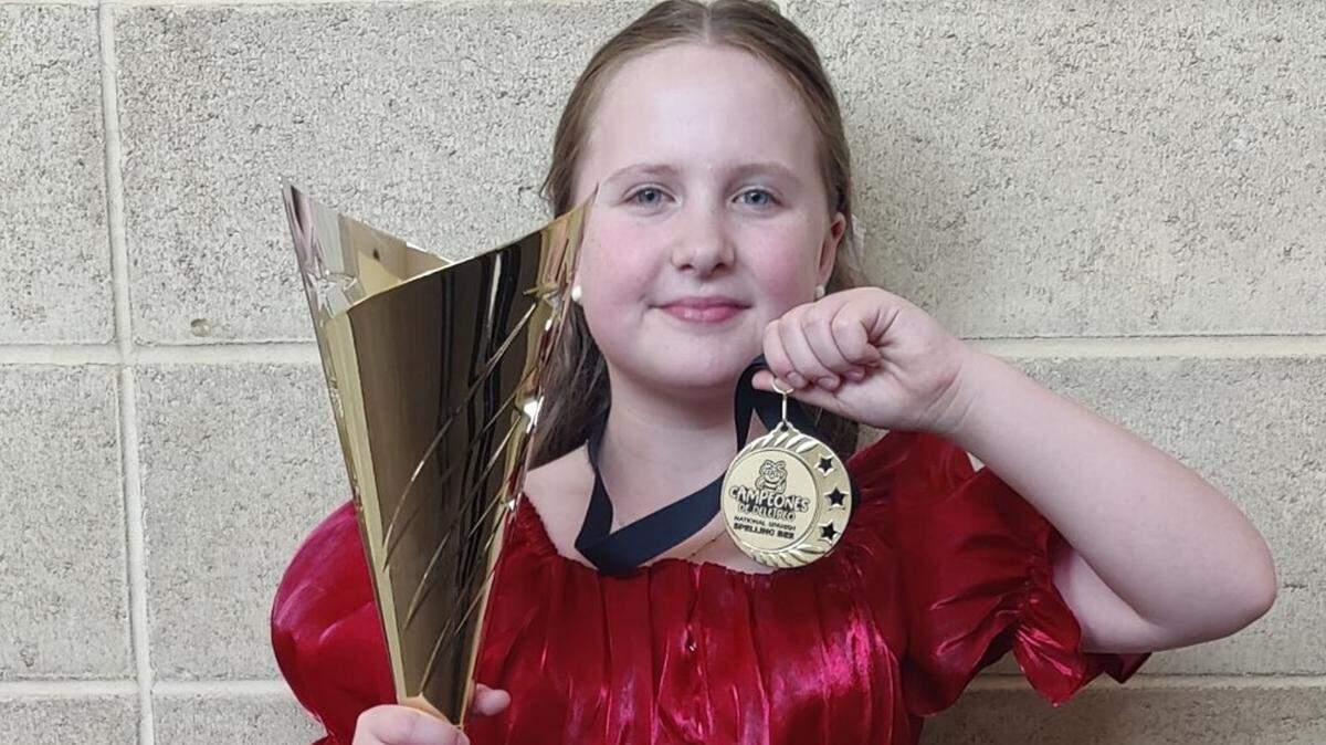 Melody Hinkle holds up her winnings from the National Spanish Spelling Bee in Albuquerque, New Mexico, on July 12.