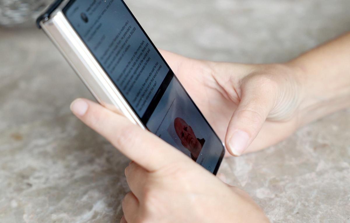 Fort Worth resident Haley Forsyth shows the post she wrote on the social media app NextDoor in February concerning her neighbor, Robert Rambo, while scrolling through her phone on Wednesday, May 1, 2024.
