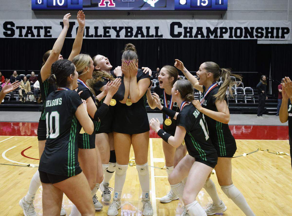 Southlake Carroll middle blocker Kinsley Young (14) receives the MVP trophy as her team mates celebrate with her after defeating Austin for the UIL Class 6A Division II state volleyball championship game Saturday Nov. 22, 2025 at Curtis Culwell Center in Garland, Texas.