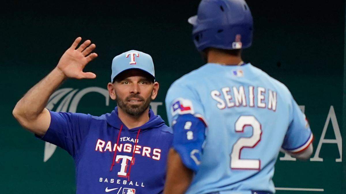 Texas Rangers manager Chris Woodward, left, congratulates Marcus Semien in one of the few happier moments of the 2022 season.