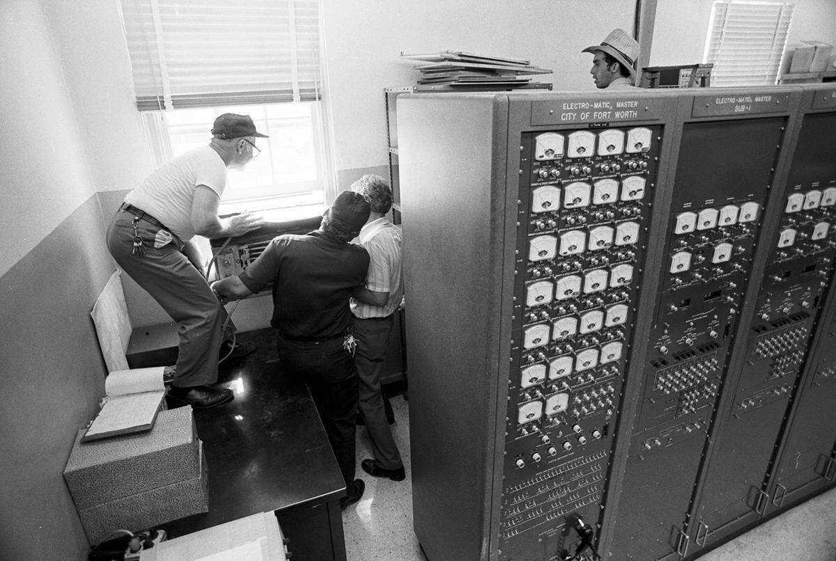 July 3, 1980: Maintenance workers in the Fort Worth Fire Department dispatch office work on repairing the air conditioning during a heat wave.