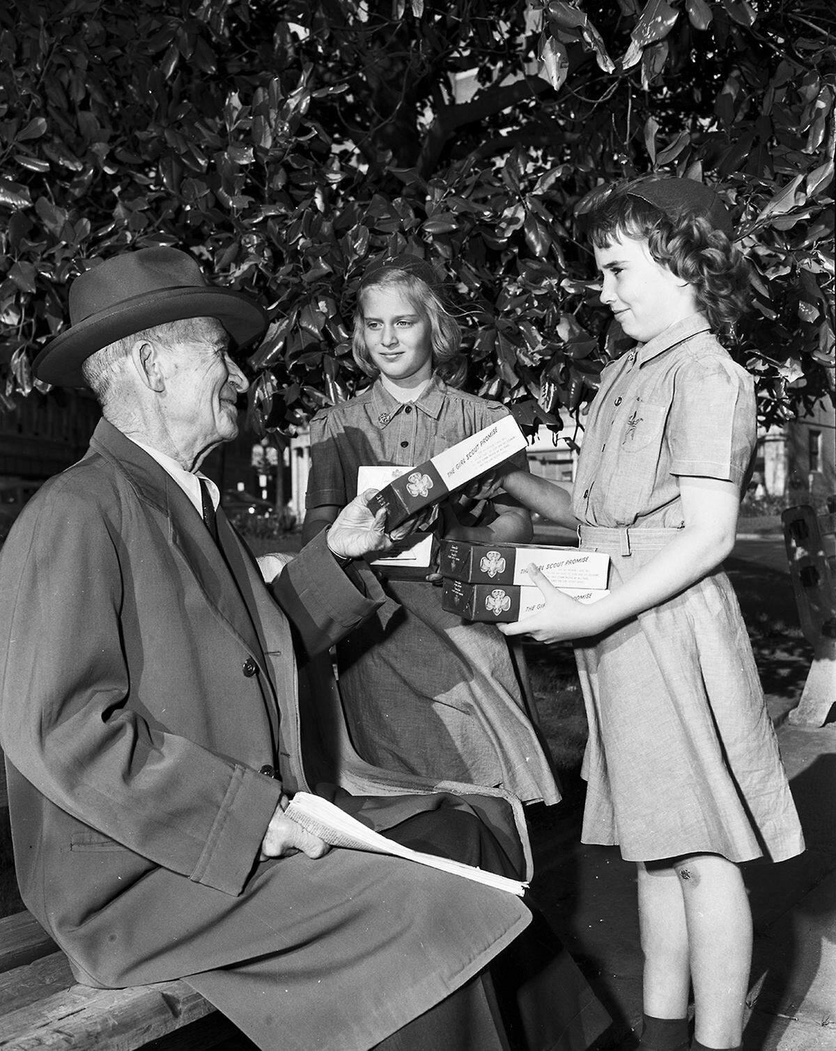 March 5, 1951: C.R. Gatewood of 905 West Leuda got more than a share of sunshine when he took a stroll in the park. He found two smiling Brownies, Judy Ward of Route 7, center, and Johnnie Kathryn Barnett of 3218 Shepherd, right, selling cookies. Brownies and Girl Scouts over Fort Worth are finding cookies a good way to sweeten the pot for Camp Timberlake, their camp on Eagle Mountain Lake.