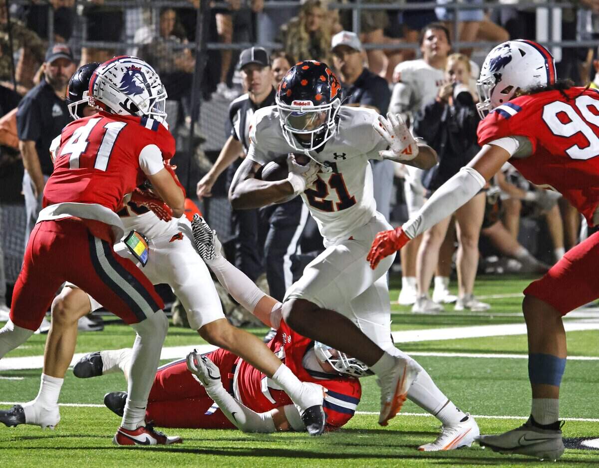 Aledo running back Kaden Winkfield (21) heads up the middle into the defense of North Richland Hills Richland defensive back Paxon Weeks (41) and defensive lineman Gevariah Kneubuhl (99) during the first half of a UIL football game on Thursday, October, 23, 2025 at Birdville FAAC Stadium in North Richland Hills, Texas.