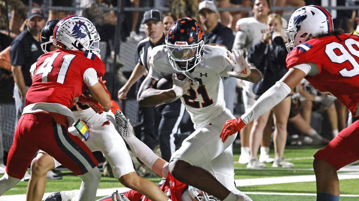 Aledo running back Kaden Winkfield (21) heads up the middle into the defense of North Richland Hills Richland defensive back Paxon Weeks (41) and defensive lineman Gevariah Kneubuhl (99) during the first half of a UIL football game on Thursday, October, 23, 2025 at Birdville FAAC Stadium in North Richland Hills, Texas.