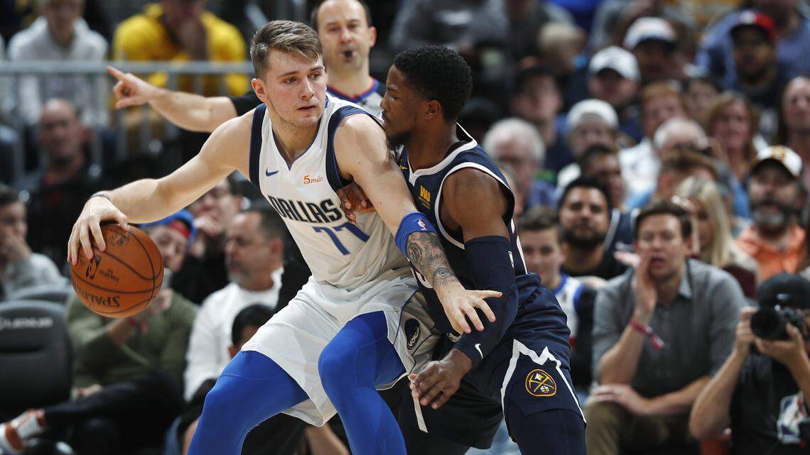 Dallas Mavericks forward Luka Doncic, left, looks to pass the ball as Denver Nuggets guard Malik Beasley defends in the second half of an NBA basketball game Tuesday, Dec. 18, 2018, in Denver. The Nuggets won 126-118. (AP Photo/David Zalubowski)