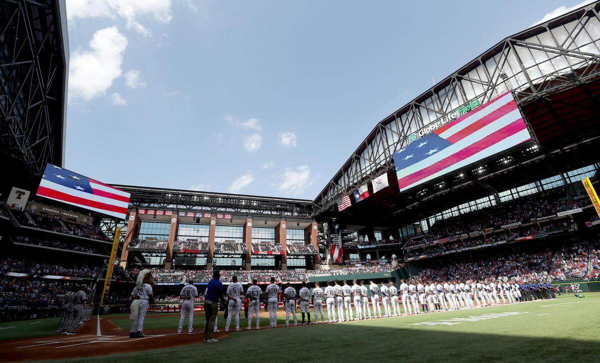 The Texas Rangers and Colorado Rockies line the baselines for the national anthem before the start of the Rangers’ home opener on Monday, April 11, 2022, at Globe Life Field.