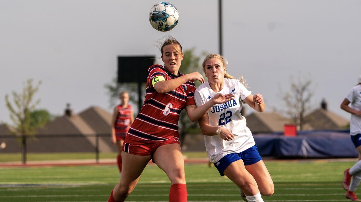 Joshua’s Maddy Bourzikas (22) battles for possession with Tatum Lowe (6) of Justin Northwest in a Class 5A area-round girls soccer match on Friday, March 29, 2024 at Boswell High School in Fort Worth ,Texas. Bourzikas finished with two goals in Joshua’s 4-1 win.