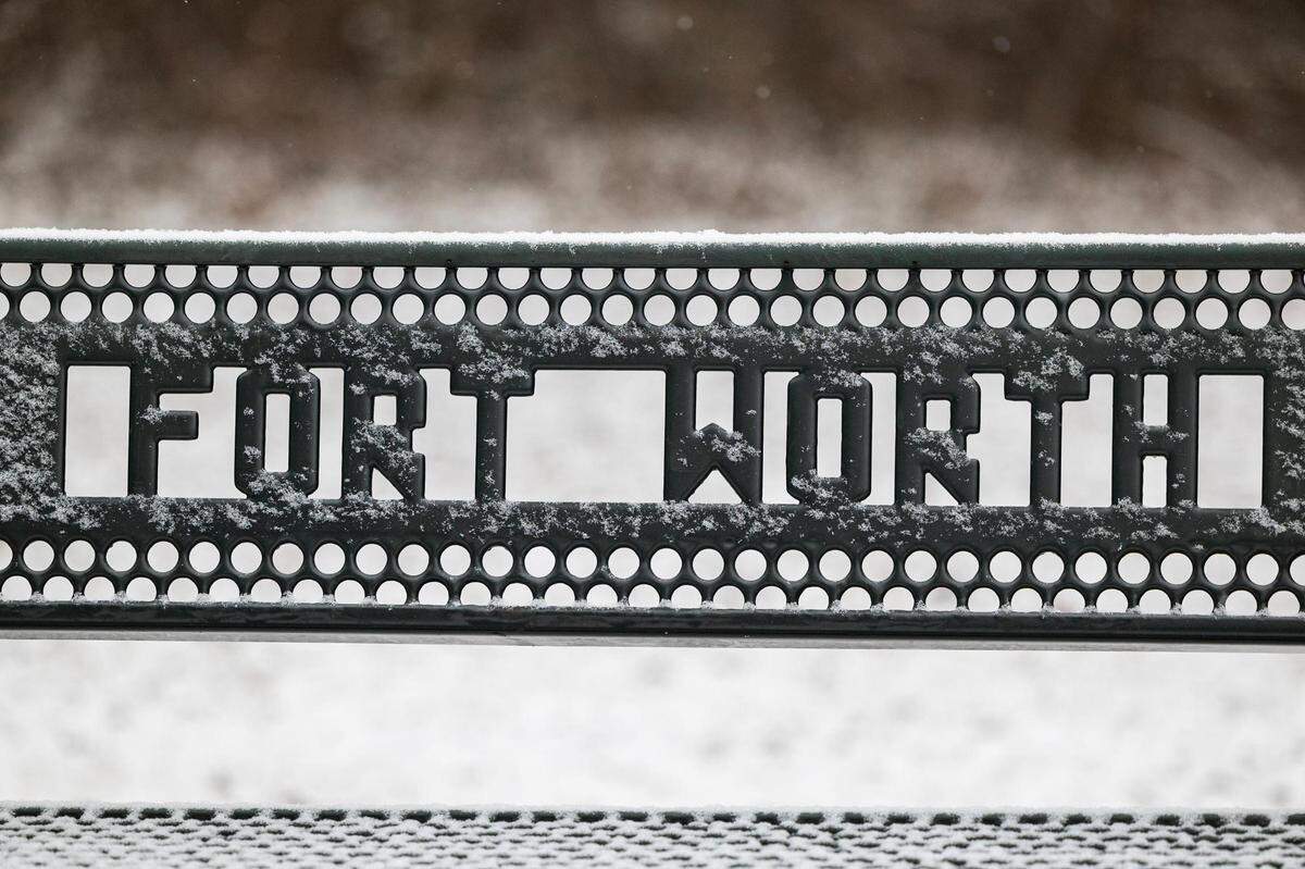 A snow-covered bench at Oakmont Park in Fort Worth on Monday, Jan. 15, 2024.