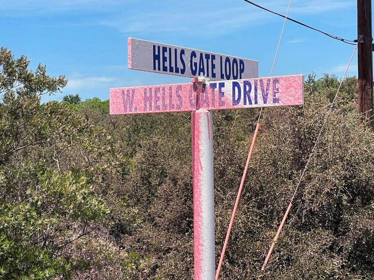 A street sign is coated by fire suppressant dropped from aircraft Friday, June 30, 2023, in Palo Pinto County.