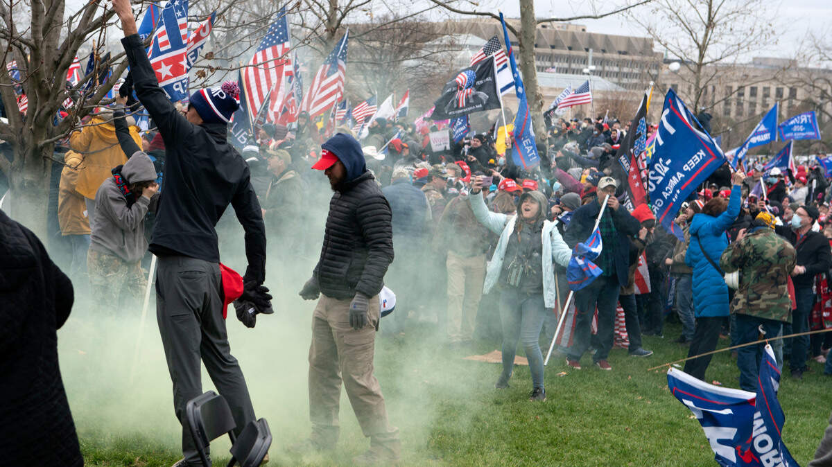 Supporter of President Donald Trump protest as U.S. Capitol Police officers shoot tear gas at demonstrators outside of the U.S. Capitol on Wednesday, Jan. 6, 2021, in Washington. (AP Photo/Jose Luis Magana)
