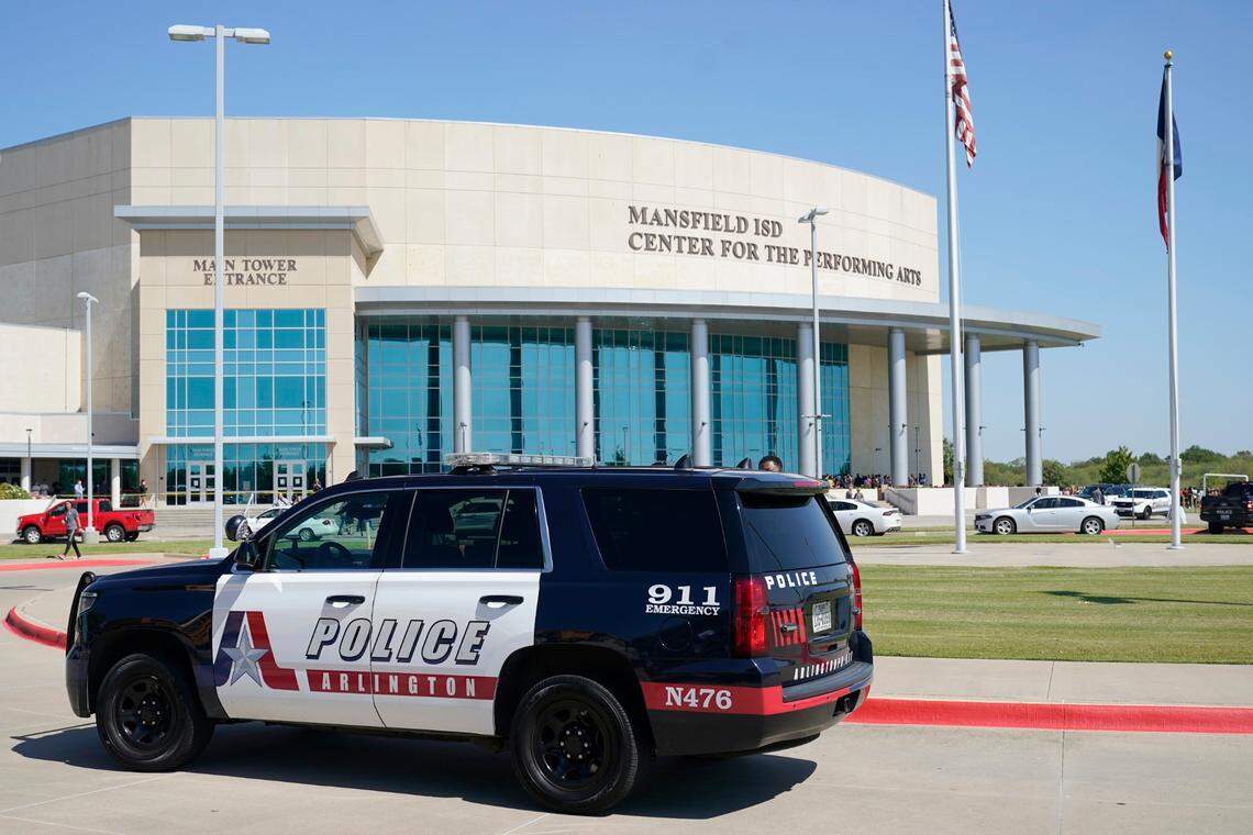 An Arlington, Texas, police vehicle sits outside the Mansfield ISD Center For The Performing Arts Wednesday, Oct. 6, 2021 in Mansfield, Texas, where families were being reunited with their children following a school shooting at Timberview High School in nearby Arlington. (AP Photo/Tony Gutierrez)