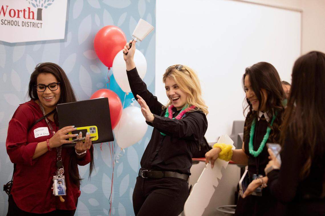 Recruitment coordinator Christina Morrow rings a cow bell, signifying a teacher candidate has been matched with a school during the Fort Worth Independent School District Summer Mega Career Fair on June 7, 2022, at the FWISD Teaching & Learning Center.