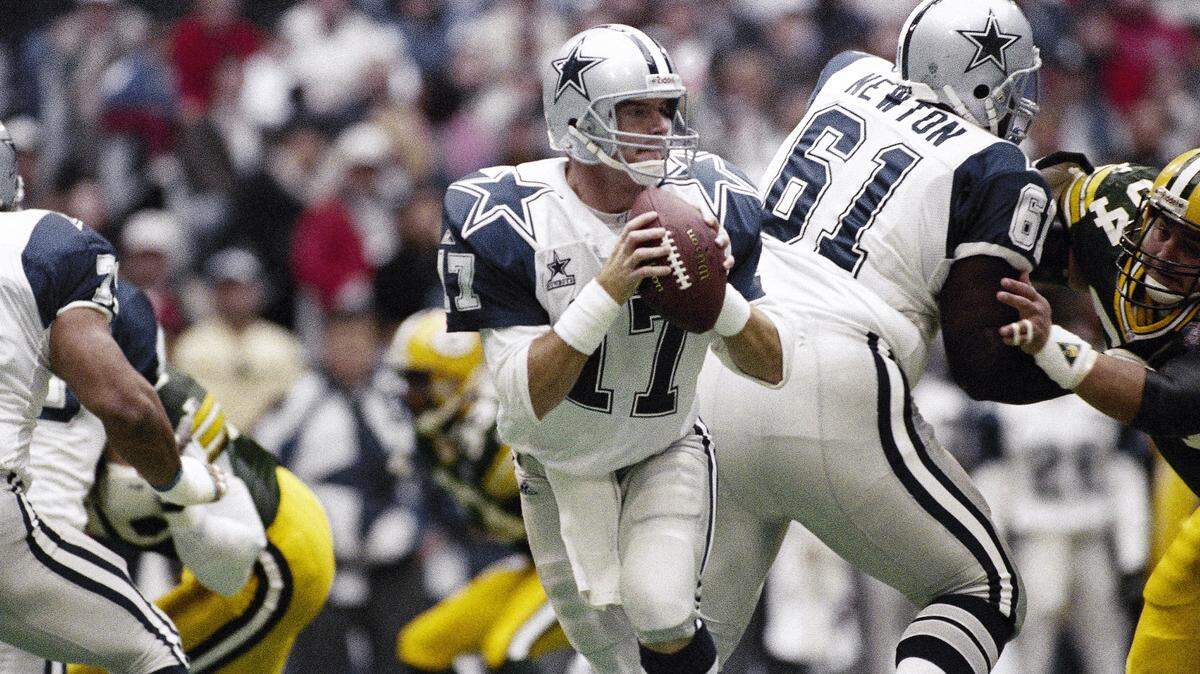 Former Dallas Cowboys quarterback and current coach Jason Garrett looks for a receiver downfield in the first quarter against the Green Bay Packers in Irving, Texas on Thursday, Nov. 24, 1994.