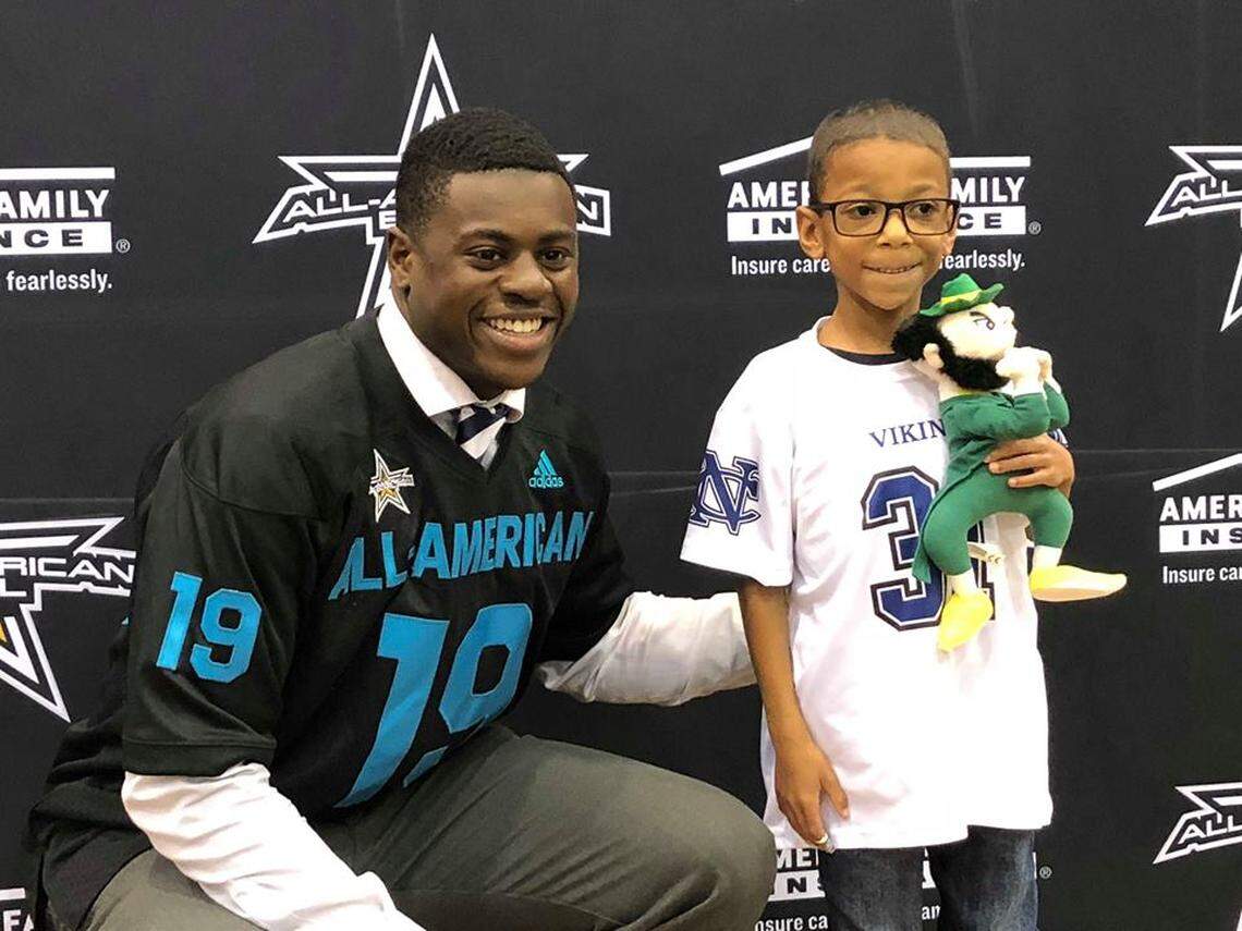 Nolan Catholic senior NaNa Osafo-Mensah with 7-year-old Jacoby Kemp.