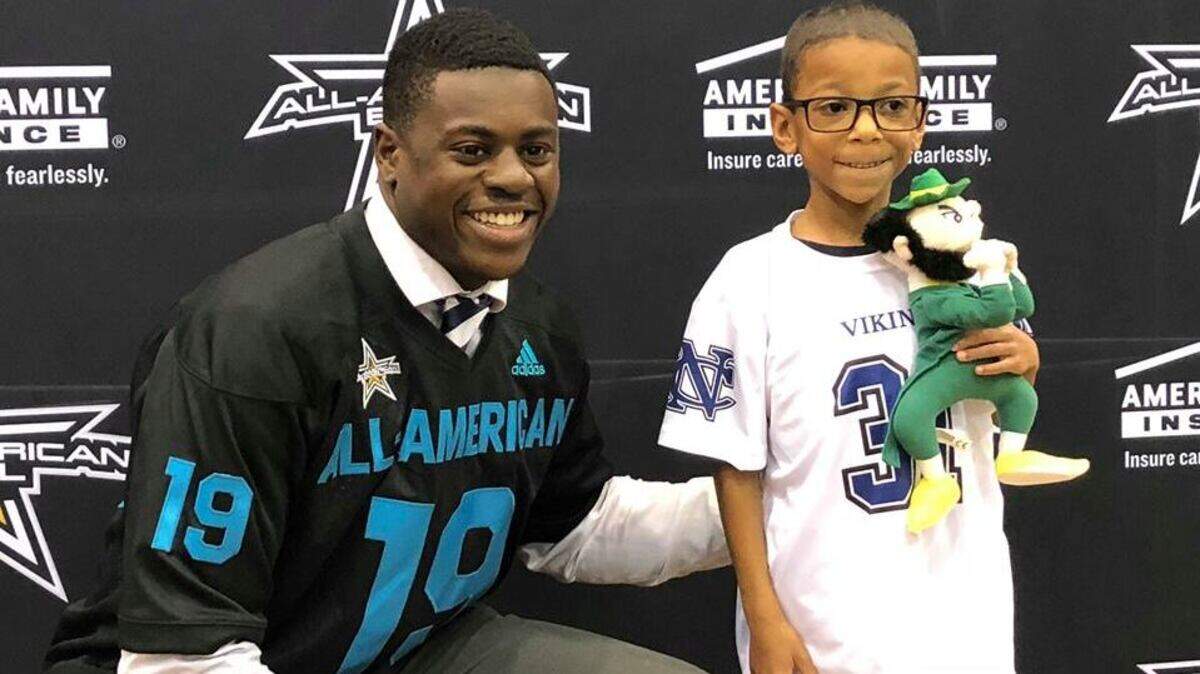 Nolan Catholic senior NaNa Osafo-Mensah with 7-year-old Jacoby Kemp.