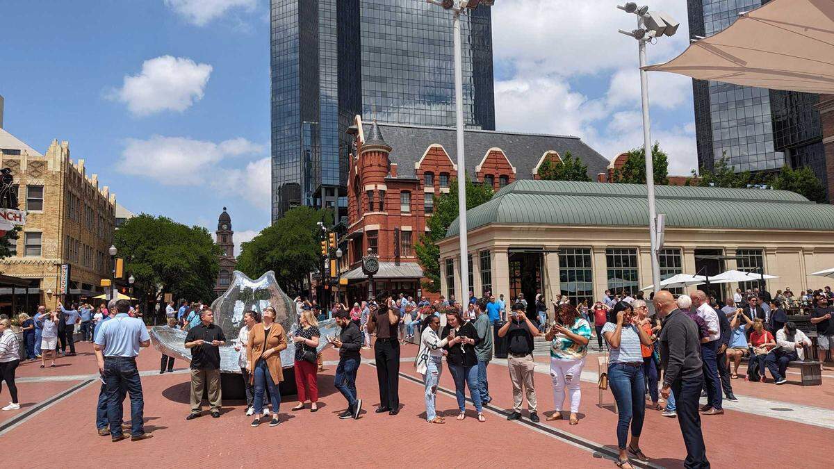 People in the Sundance Square plaza look up at the eclipse on Monday, April 8, 2024, in Fort Worth. 