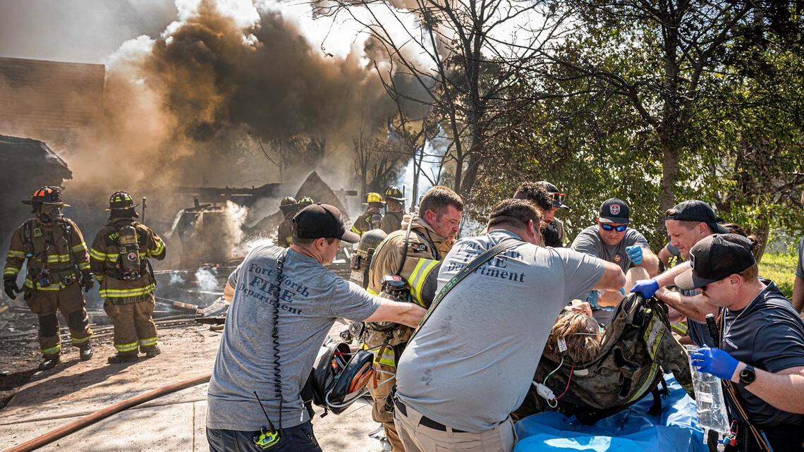 Fort Worth Fire Department medics provide treatment to an injured firefighter at the scene of a house fire on Wednesday, Sept. 3, 2025.