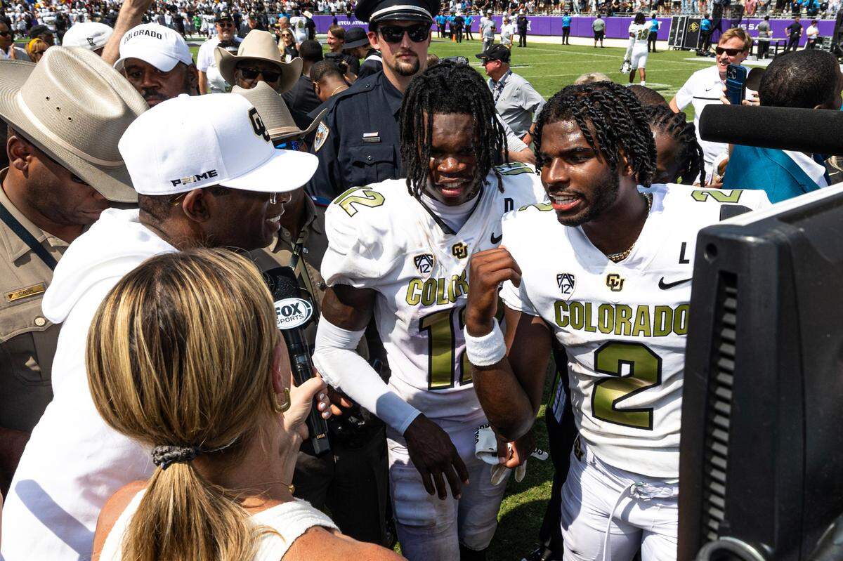 Colorado quarterback Shedeur Sanders (2) talks to his father and head coach Deion Sanders following the Buffaloes win over TCU on Saturday, September 2, 2023, in Fort Worth.