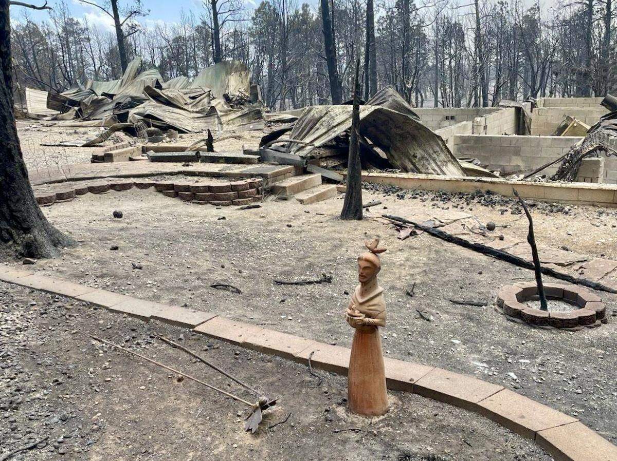 A figurine of St. Francis, the Roman Catholic patron saint of animals, stands guard at the debris of Dave Millsap and Carol Boggs’ home in Ruidoso, New Mexico, June 17, 2024.