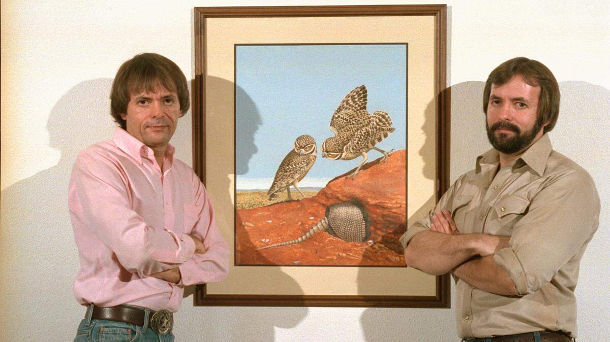 The Gentling twins, Scott, left, and Stuart, pictured in 1986, the year their monumental portfolio book, “Of Birds and Texas,” was published. They stand alongside their watercolor titled “Burrowing Owl.”