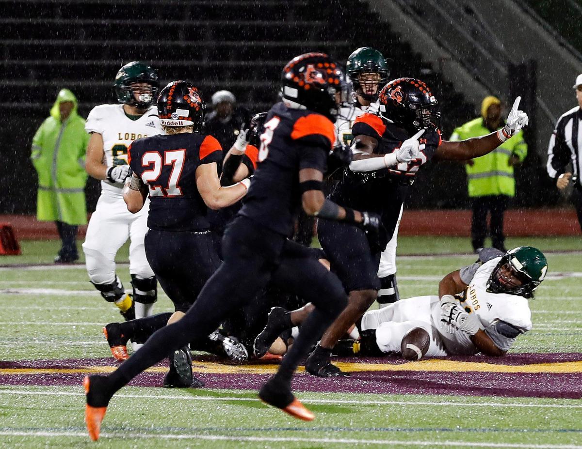 A Longview player lays on the turf as the Aledo Bearcats run off the field celebrating their win of a UIL Class 5A D1 state semifinal football game at the John Kincaide Stadium in Dallas, Texas, Saturday, Dec. 10, 2022. Under two hours of weather delays Aledo defeated Longview 17-14. (Special to the Star-Telegram Bob Booth)