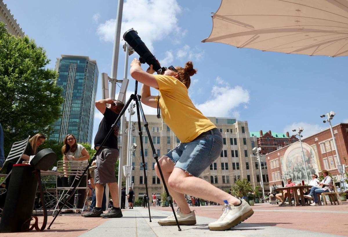 Garrett Minnie views the eclipse as it begins in Sundance Square in downtown Fort Worth on Monday, April 8, 2024.