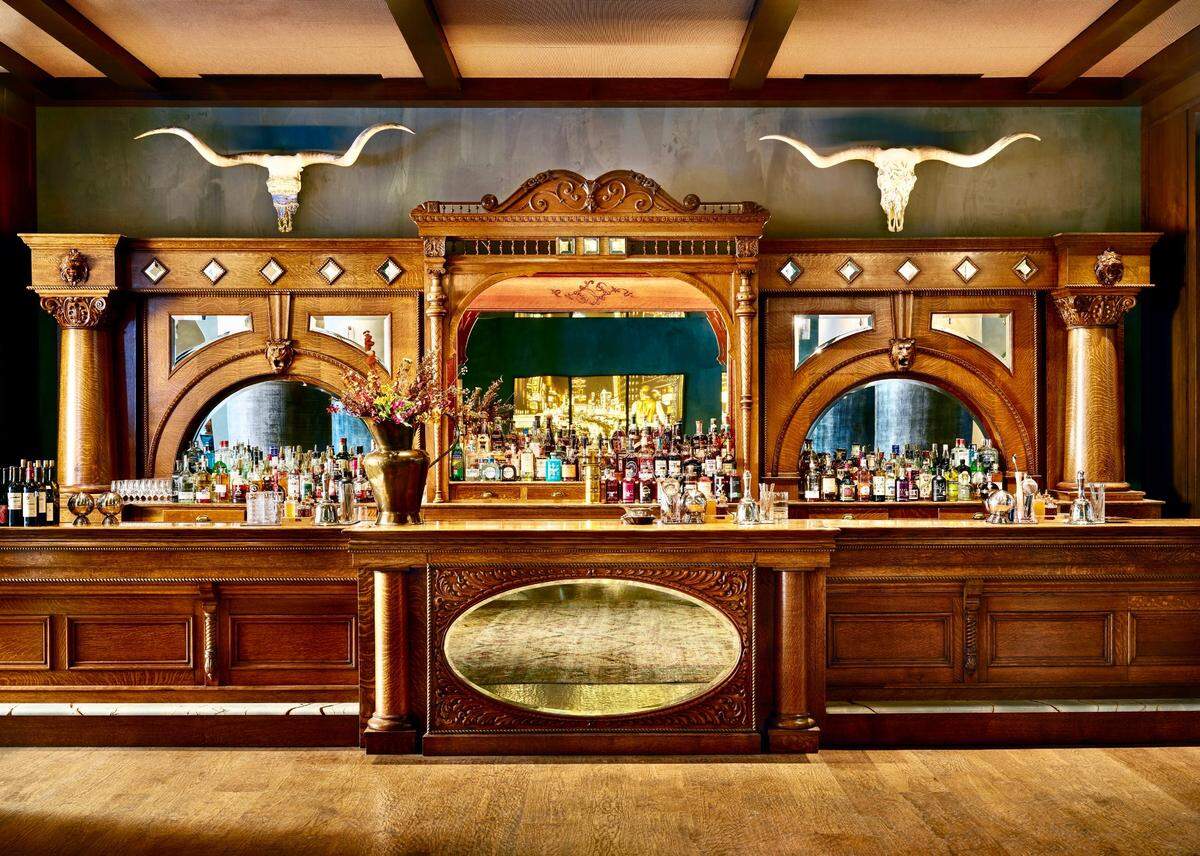 The western-style bar in a room laden with elegant furniture and art at the Bowie House, Auberge Resorts Collection hotel in Fort Worth.