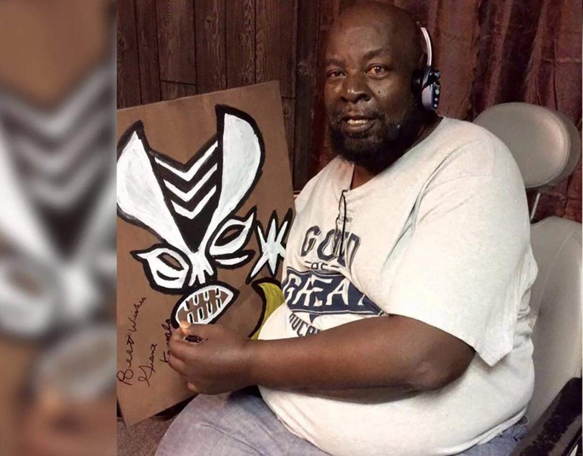 Mississippi wrestler James Harris poses with memorabilia from his 1980s pro wrestling days as “Kamala, the Ugandan Giant.” Harris became a top draw in World Wrestling and elsewhere as a menacing but bumbling Ugandan tribal warrior, fated always to lose to his white opponents. He died of COVID-19 in Mississippi on Aug. 9, 2020, at age 70.