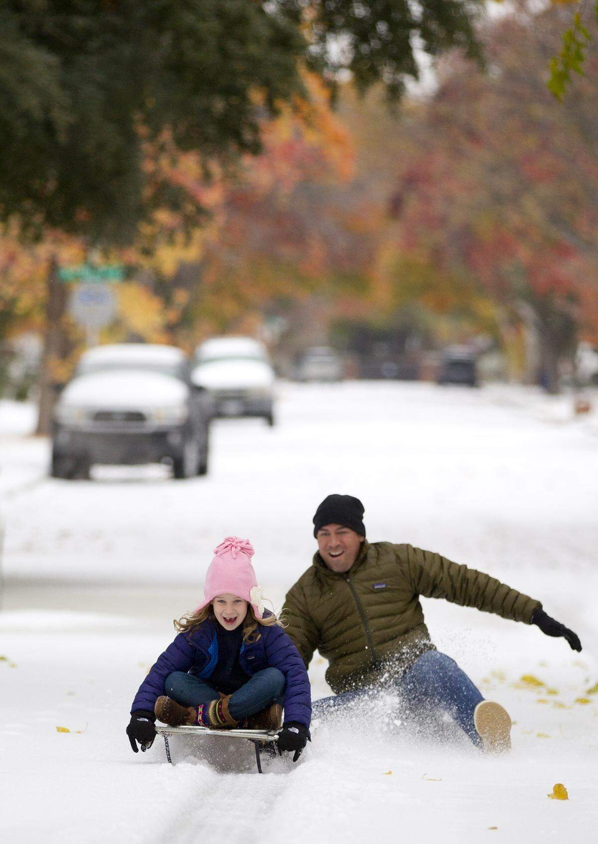 Mark Vogel gives his daughter Parker, 7, a push on the sled he used when he was a kid on the icy streets in west Fort Worth on Friday, Dec. 6, 2013.