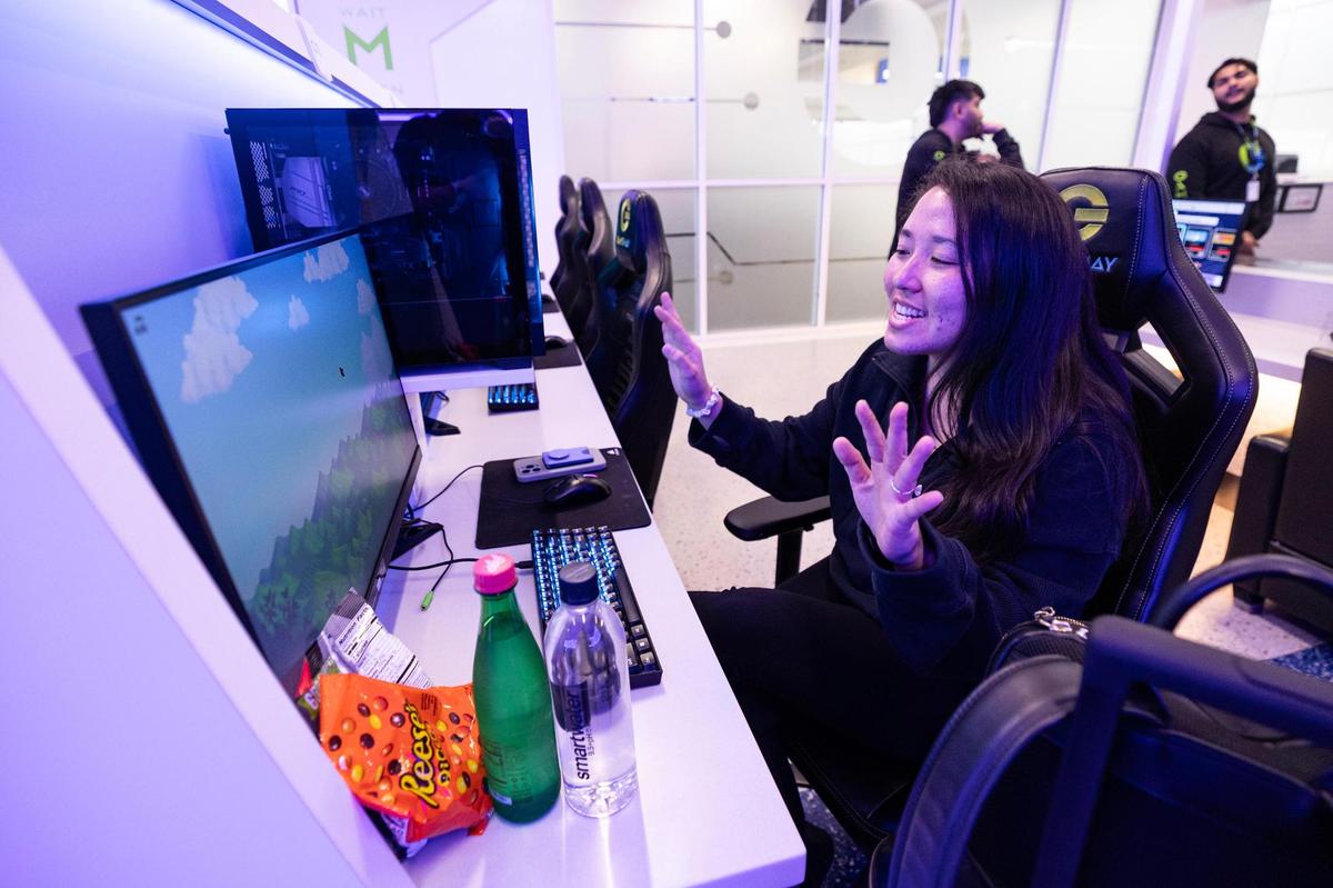 New York resident Maya Allen reacts to using one of the PC consoles at Gameway video game lounge in Terminal E at Dallas Fort Worth International Airport on Wednesday, March 26, 2025.
