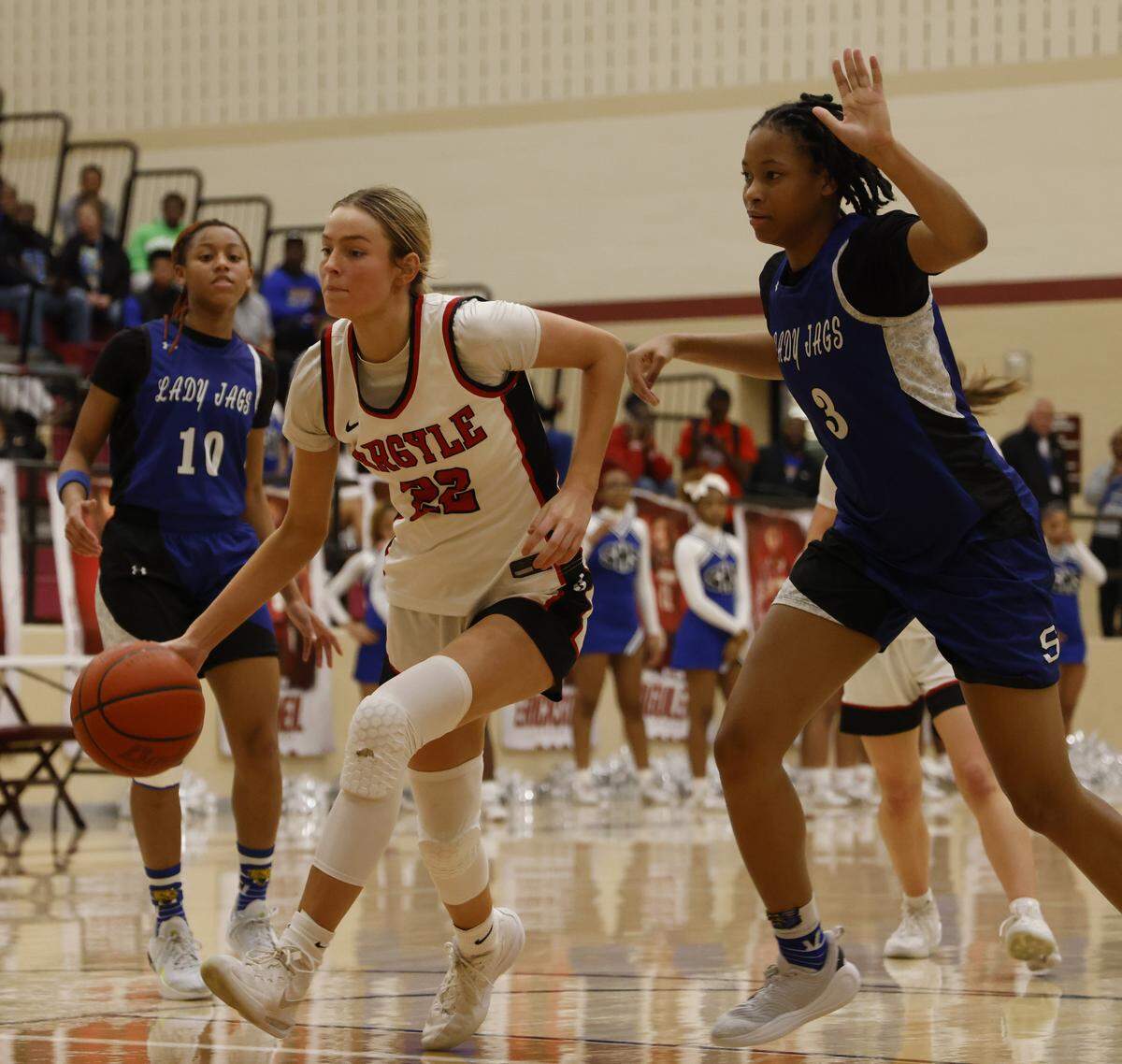 Argyle forward Landry Murphy (22) drives between Mansfield Summit guards Kyleigh Smith (10) and Kyndal Hardaway (3) during the second half of a UIL Class 5A DII girls playoff basketball game at Saginaw High School in Saginaw, Texas, Thursday Feb. 19, 2026.