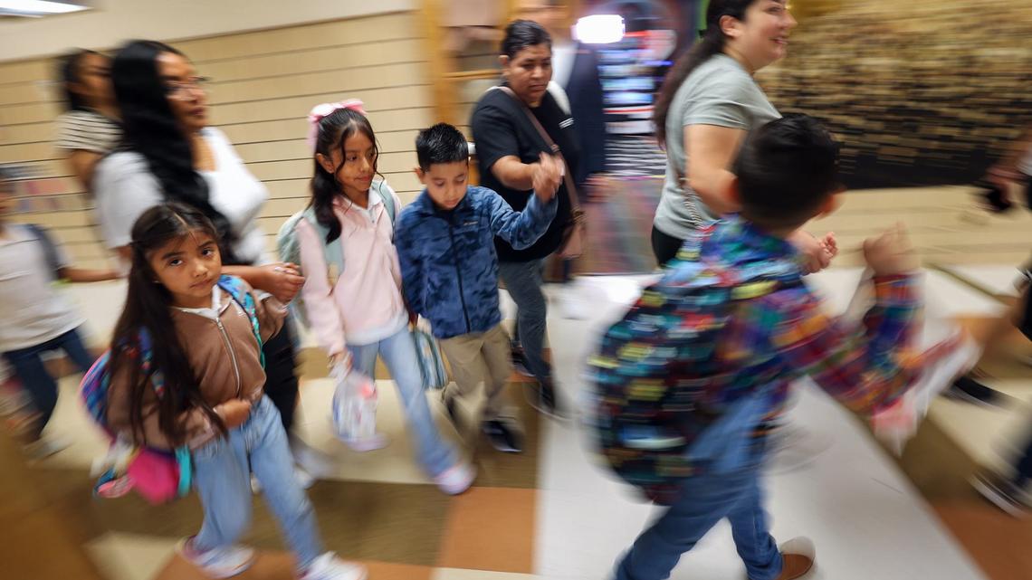 Students and parents rush to the first class of the first day of school at M.H. Moore Elementary School on Tuesday, Aug. 13, 2024.
