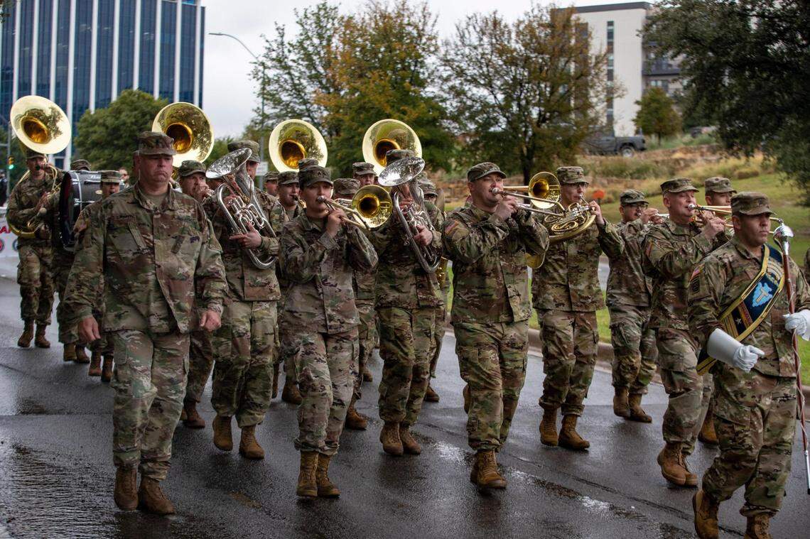 A military band leads the the Veterans Day Parade through Fort Worth on Friday, Nov. 11, 2022. Despite rain, hundreds of participants marched down North Forest Park Boulevard, waving American flags and signing a medley of military songs.
