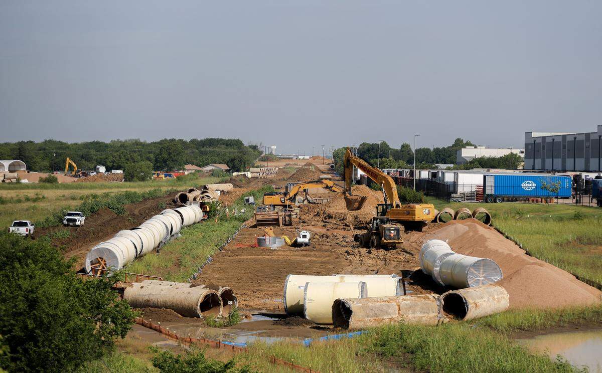 Construction workers dig near The Canals in north Mansfield on June 3, 2026. The Canals, a $1 billion mixed-use development, will be the site of the new city hall.